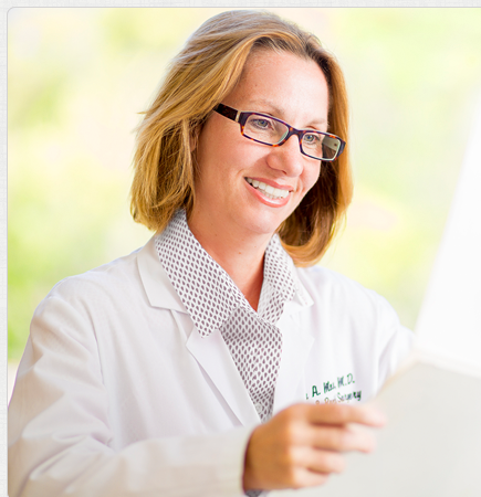 A woman in white lab coat holding papers.